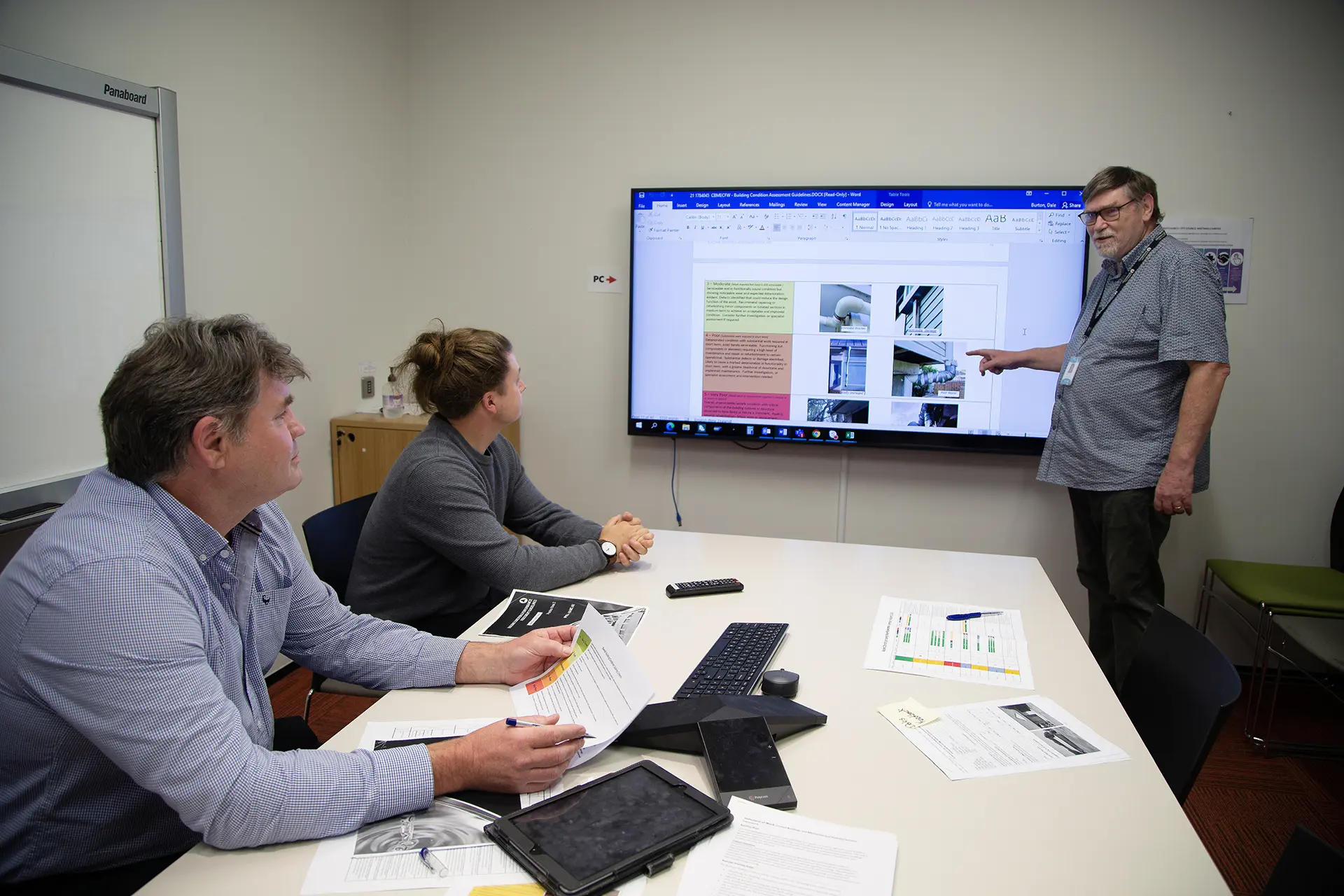 Christchurch City Council team in a meeting room reviewing a Business Analysis project on a large screen.