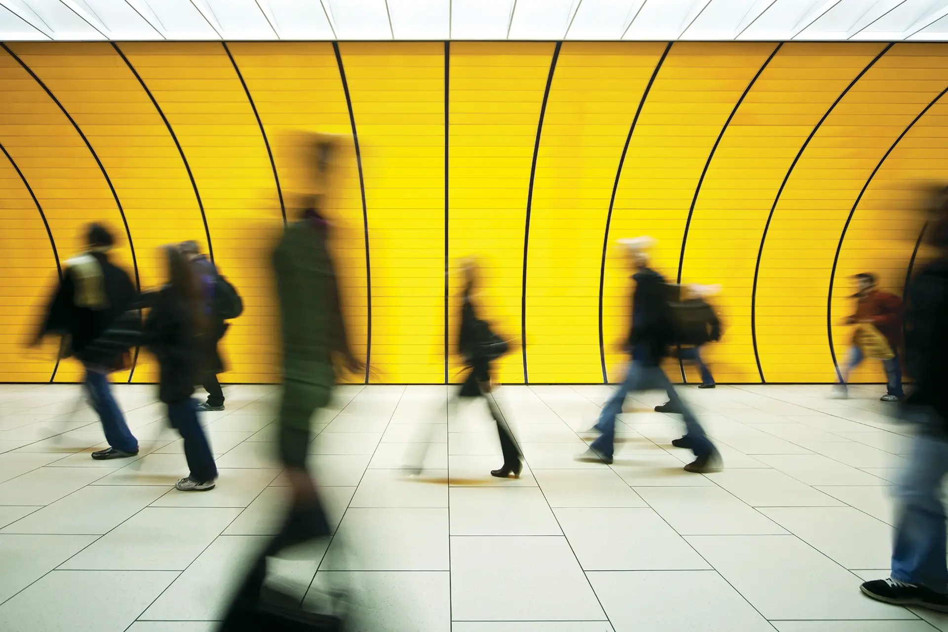 A busy station hallway filled with pedestrians, capturing the hustle and bustle of peak hour travel.
